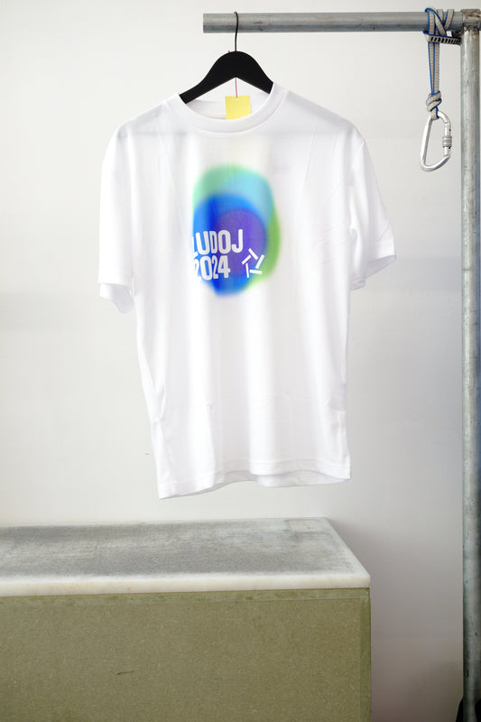 White short-sleeve T-shirt hanging on a black hanger. Featuring a colorful graphic, against white background.