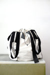 white soil sack with black fabric handles, against a white background.