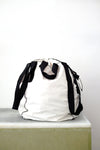 white soil sack with black fabric handles, against a white background.