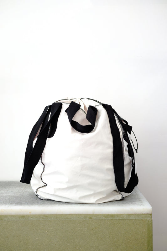 white soil sack with black fabric handles, against a white background.