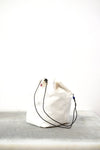 White drawstring bag with white drawstrings and GR10K logo patch, against a plain white wall.
