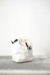 white drawstring bag with white drawstrings and GR10K logo patch, against a plain white wall.