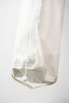 white kit bag detail, against a plain white wall.